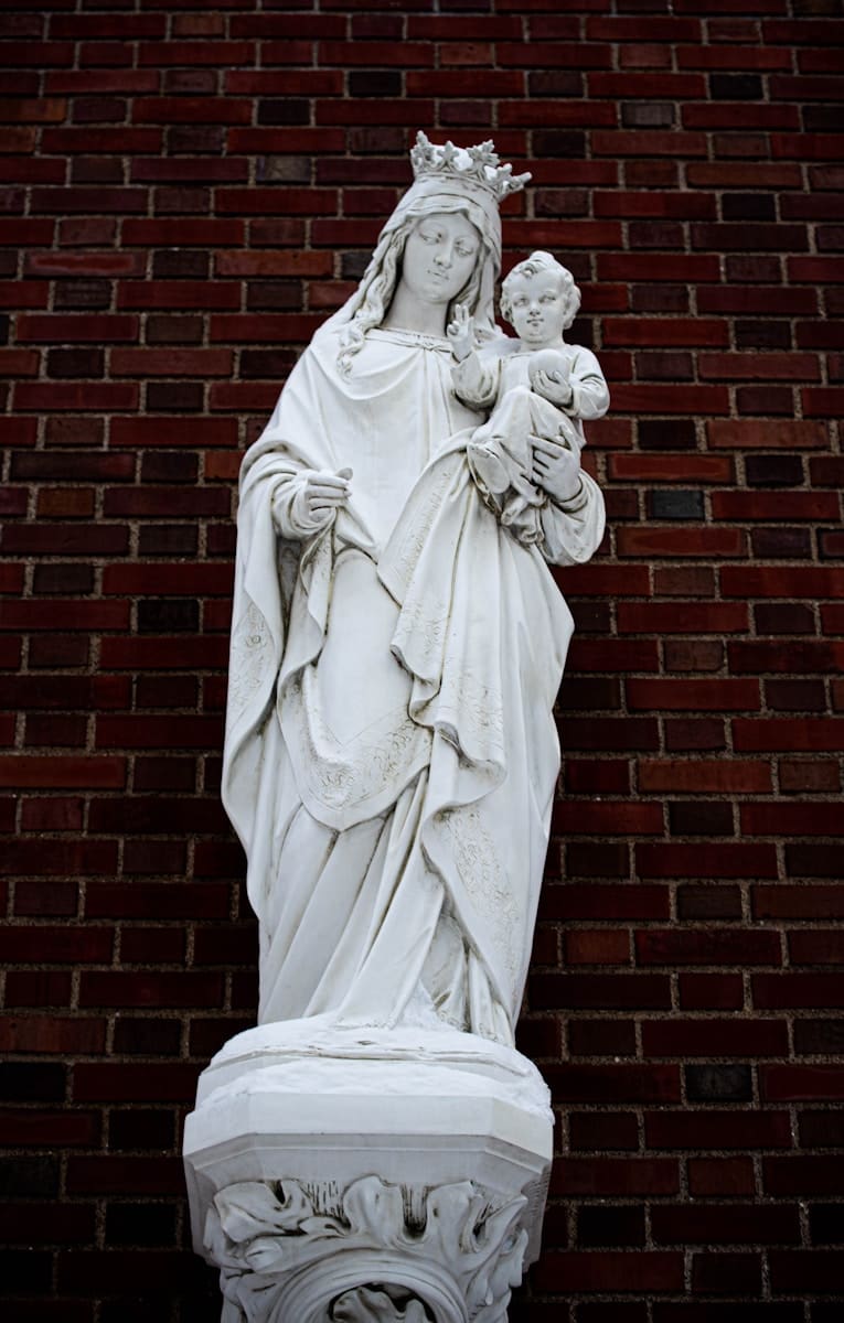 Photo by Gianna B a statue of the virgin mary holding a child
